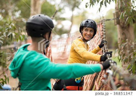 Couple interacting with each other on rope bridge Couple interacting with each other on rope bridge 36851347
