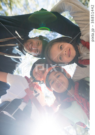 Portrait of instructor and kids forming huddle 36851442