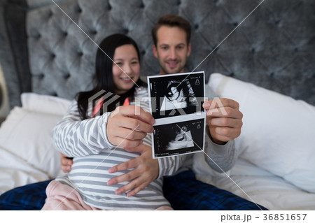 Man and pregnant woman looking at sonography Man and pregnant woman looking at sonography 36851657