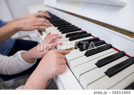Mid section of mother and daughter playing piano Mid section of mother and daughter playing piano 36851666