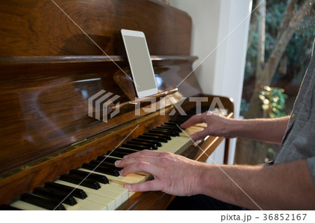 Man playing piano at home Man playing piano at home 36852167