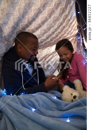 Father and daughter using mobile phone in bedroom 36852227