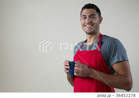 Smiling waiter holding a cup of coffee Smiling waiter holding a cup of coffee 36852278