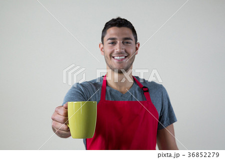 Smiling waiter offering a cup of coffee Smiling waiter offering a cup of coffee 36852279