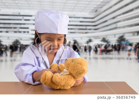 Asian girl playing as a doctor care bear doll Asian girl playing as a doctor care bear doll 36856749