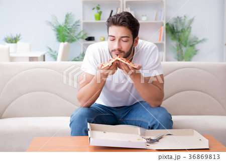 Man eating pizza having a takeaway at home 36869813