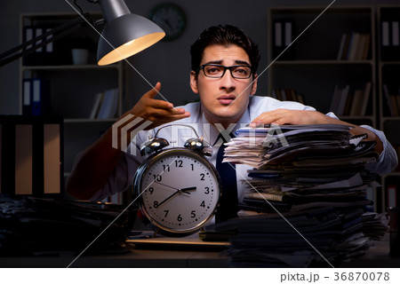 Young businessman working overtime late in office Young businessman working overtime late in office 36870078