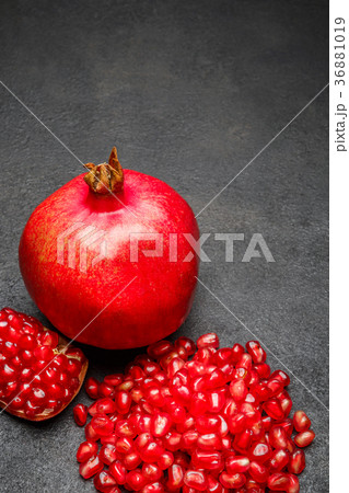 Pomegranate and seeds close-up on dark concrete Pomegranate and seeds close-up on dark concrete 36881019