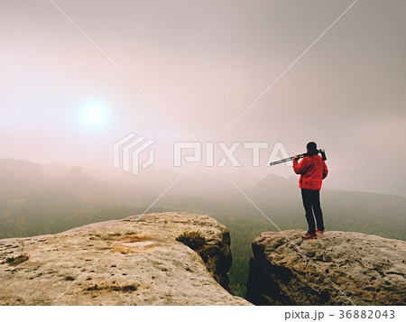Photographer think about picture on peak in mist Photographer think about picture on peak in mist 36882043