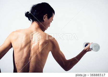 ダンベルで筋トレをするミドル男性 後ろ姿の写真素材
