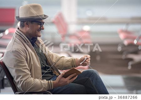 Cheerful mature traveler is holding ticket 36887266