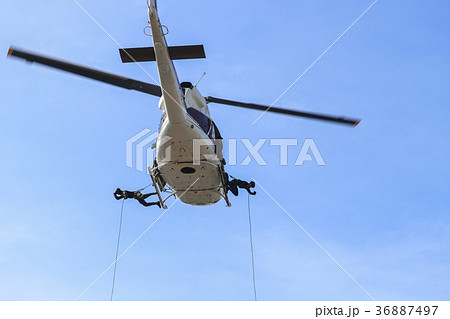 Soldier rappelling from helicopter in blue sky 36887497