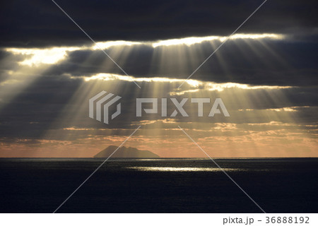 北海道桧山沖の日本海渡島大島に降り注ぐ光の筋 光芒の風景を撮影の写真素材