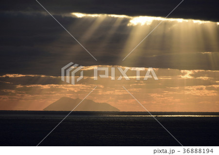 北海道桧山沖の日本海渡島大島に降り注ぐ光の筋 光芒の風景を撮影の写真素材