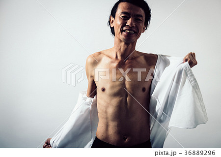 シャツを脱ぐミドル男性 腹筋 筋肉の写真素材 3696
