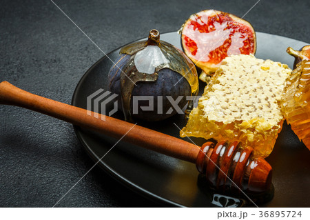 Figs with honey on in the plate on dark concrete 36895724