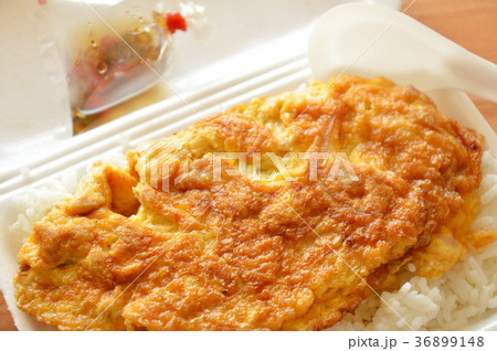 fried egg on rice in foam box with plastic spoon  36899148