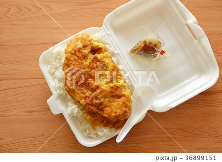fried egg on rice in foam box with plastic spoon  36899151
