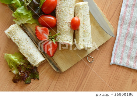 bread roll and salad on wooden chop block 36900196