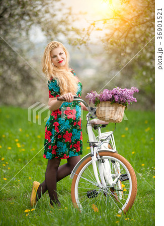 Girl with vintage white bicycle with flowers basket 36901521
