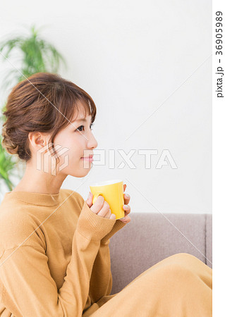 部屋で飲み物を飲む女性 36905989