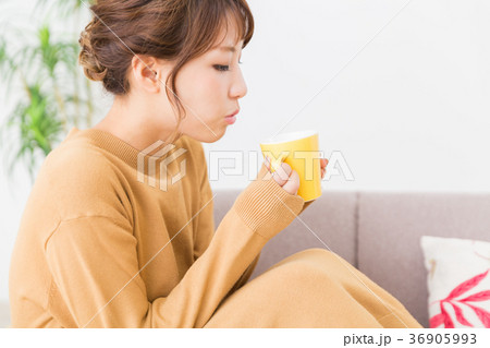 部屋で飲み物を飲む女性 36905993