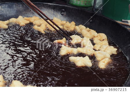 Making deep-fried dough stick in market. Making deep-fried dough stick in market. 36907215