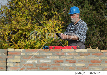 Worker examining brick wall Worker examining brick wall 36920462