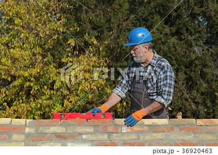 Worker examining brick wall Worker examining brick wall 36920463