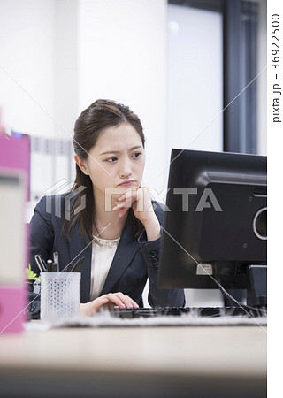 オフィスでパソコンを見て悩む若い女性社員 オフィスでパソコンを見て悩む若い女性社員 36922500