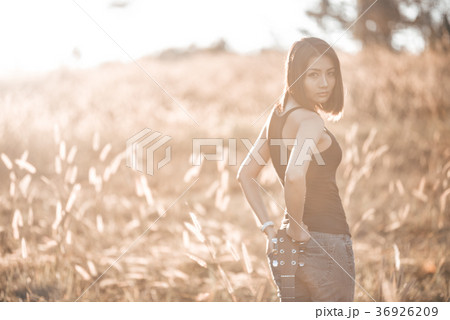 Beautiful young girl carrying her guitar 36926209