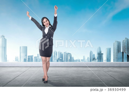 Excited asian business woman standing on the rooftop Excited asian business woman standing on the rooftop 36930499