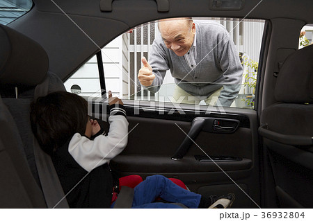 孫を見送るシニア 36932804