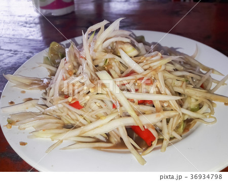 Papaya salad in a plate on a table. Papaya salad in a plate on a table. 36934798