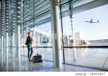 Young woman waiting at airport, looking through 36934857