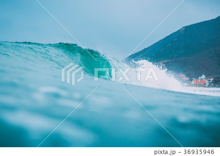Blue wave in ocean. Surfing swell and cloudy sky 36935946