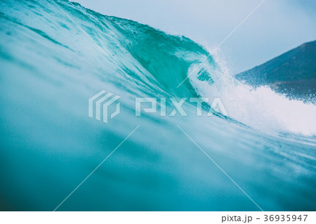 Blue surfing wave breaks in the ocean 36935947