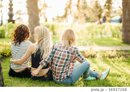 three girls having fun in the sunset park. rear 36937108