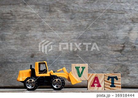 Yellow plastic bulldozer hold letter V to word VAT 36938444