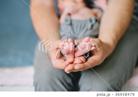 father holding newborn baby little feet 36938479