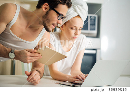 Couple with laptop and tablet in kitchen 36939316