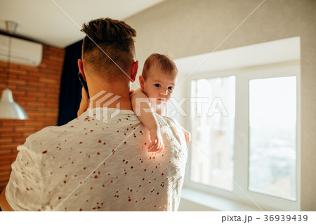 young father holding his newborn baby son young father holding his newborn baby son 36939439
