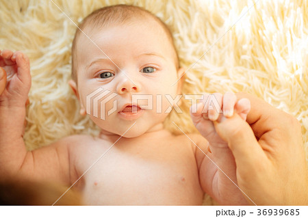 newborn baby lying down smiling looking at camera newborn baby lying down smiling looking at camera 36939685