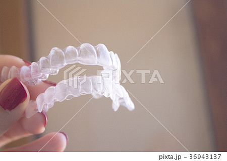 Invisible dental orthodontics held by a woman 36943137