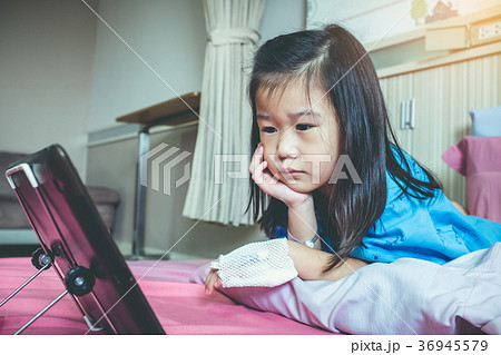 Cute asian child using tablet with iv drip on hand 36945579