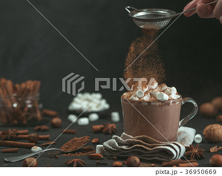 cinnamon powder flying over glass mug with hot 36950669