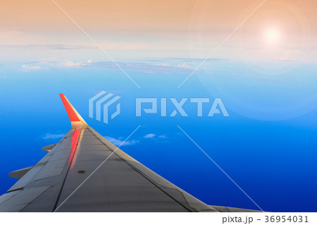 Sunset, cloudy sky and airplane wing  36954031