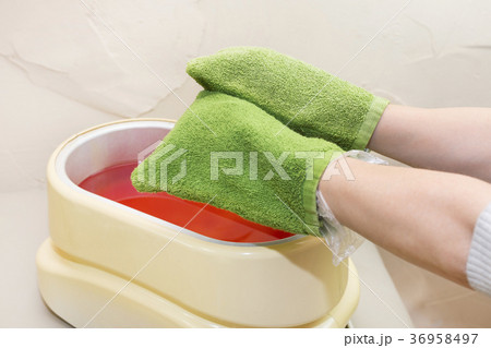 Process paraffin treatment of female hands in beau Process paraffin treatment of female hands in beau 36958497