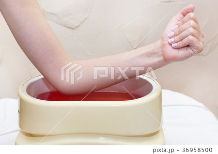 Process paraffin treatment of female hands in beau Process paraffin treatment of female hands in beau 36958500
