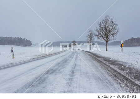 Lonely icy winter road with white snowy track 36958791
